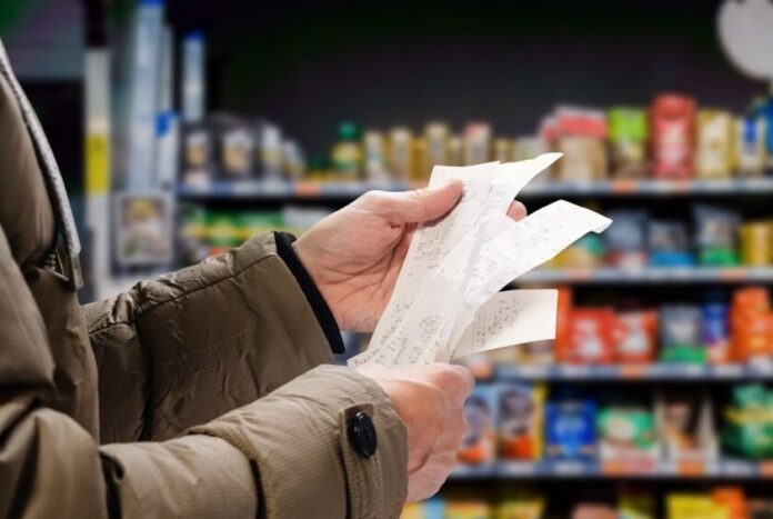 Minded,Man,Viewing,Receipts,In,Supermarket,And,Tracking,Prices